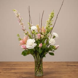 Pink and white floral arrangement in a clear glass vase