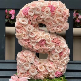 Large floral letter S covered in pale pink roses