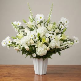 White floral arrangement in a tall white vase