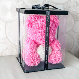 Pink rose teddy bear in a clear gift box with a black ribbon