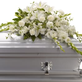 White floral spray on a silver casket
