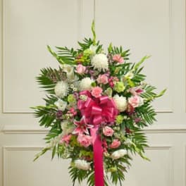 Standing floral spray with pink and white flowers and a bright ribbon