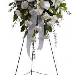 White funeral spray on a standing easel with ribbon