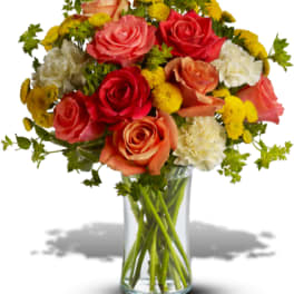 Mixed bouquet of roses and carnations in a clear glass vase