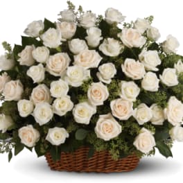 Basket of cream and white roses with greenery