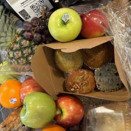 Fruit gift basket with apples, grapes, pineapple, muffins, and packaged coffee