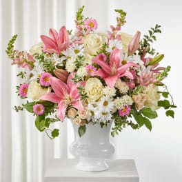 Pink lilies and white roses in a white vase