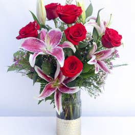 Bouquet of red roses and pink lilies in a glass vase