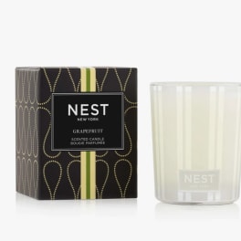 Scented candle in a glass tumbler beside its box