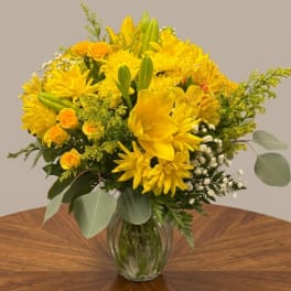Yellow floral bouquet in a clear glass vase