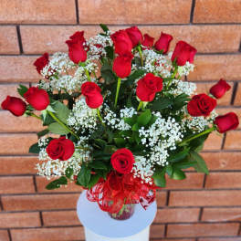 Bouquet of red roses with white baby's breath in a glass vase