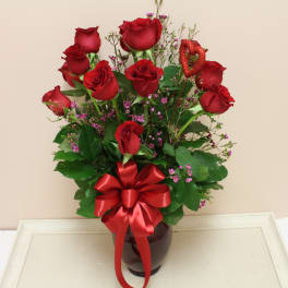 Red roses in a vase with a red ribbon bow