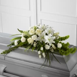 White floral spray on a gray casket