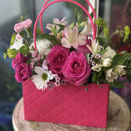 Pink rose bouquet in a bright pink handbag-style container