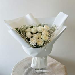 Bouquet of cream roses with baby's breath in white wrapping