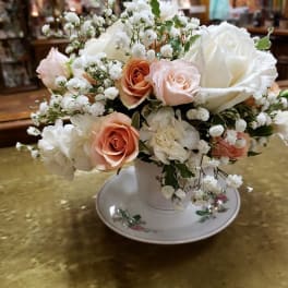 Bouquet of white and peach roses in a white vase