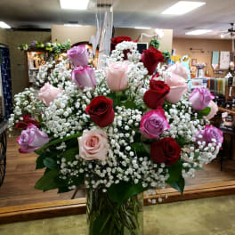 Bouquet of red, pink, and lavender roses in a glass vase