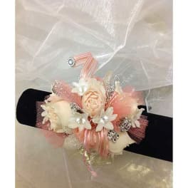 Corsage with cream flowers and pink ribbon on a black band
