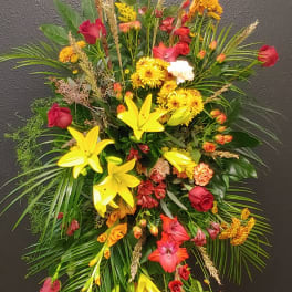 Large standing spray with red roses, yellow lilies, and mixed blooms