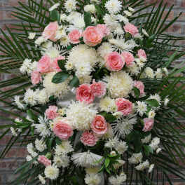Pink roses and white chrysanthemums arranged in a large standing spray