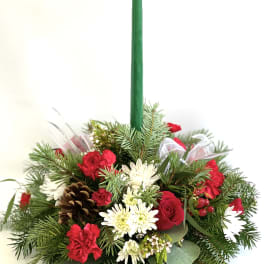 Holiday centerpiece with a green taper candle and red-white flowers