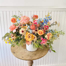 Colorful mixed flower arrangement in a white container