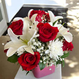 Red roses and white lilies in a pink vase