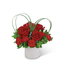 Red roses and carnations in a white cylindrical vase