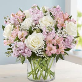 Pink and white bouquet of roses and alstroemeria in a clear glass vase