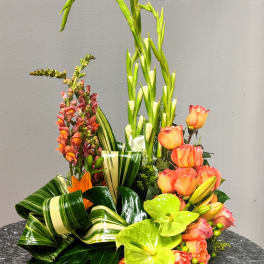 Tropical floral arrangement with orange roses and green anthuriums