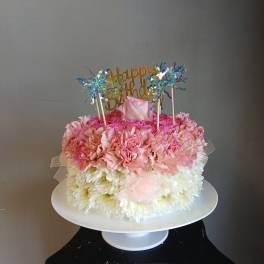 Pink and white flower cake with a Happy Birthday topper
