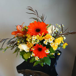 Bright mixed bouquet with orange gerberas, yellow roses, and white calla lilies