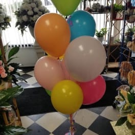 Cluster of colorful balloons in a flower shop display