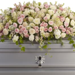 Pastel floral spray on a silver casket
