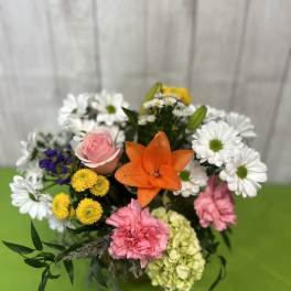 Mixed bouquet with a pink rose, orange lily, and white daisies