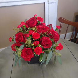 Red roses and carnations arranged in a black vase