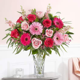 Pink and red rose bouquet with gerbera daisies in a clear glass vase