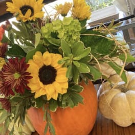 Sunflower and mixed fall bouquet arranged in a pumpkin vase