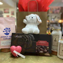 Gift basket with a teddy bear, chocolates, coffee, bath crystals, and hand cream