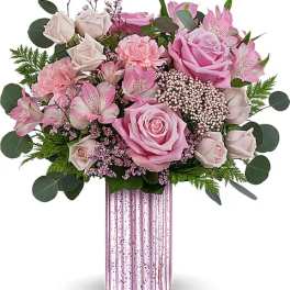 Pink roses and alstroemeria in a pink glass vase