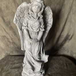 Gray angel statue with folded hands and wings
