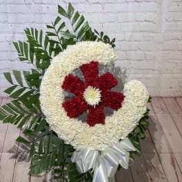 Large floral wreath with red and white flowers and a white ribbon bow