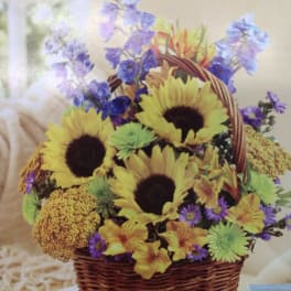 Basket arrangement with sunflowers, purple flowers, and yellow blooms