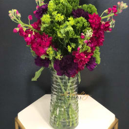 Bright pink and purple flowers in a clear glass vase