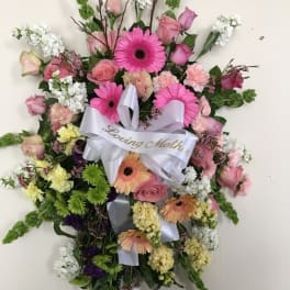 Heart-shaped floral wreath with pink and white flowers and a ribbon