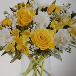 Yellow and white rose bouquet in a clear glass vase
