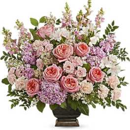 Pink roses and lavender flowers arranged in a dark vase