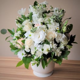 White floral arrangement in a round white vase
