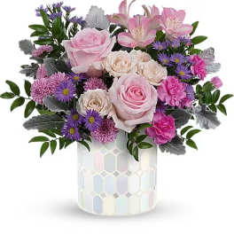 Pink and purple flower arrangement in a mosaic vase