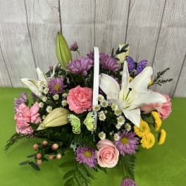 Basket arrangement with lilies, pink carnations, daisies, and roses